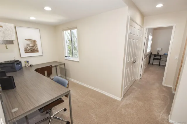 a view of a workspace with furniture and a window
