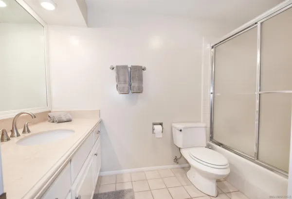 a bathroom with a granite countertop sink a toilet and a mirror