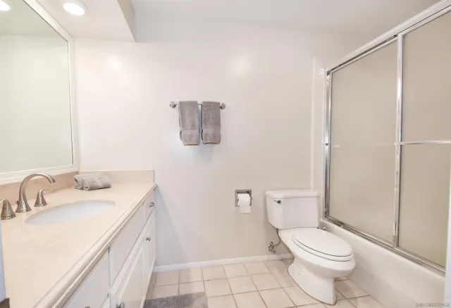 a bathroom with a granite countertop sink a toilet and a mirror