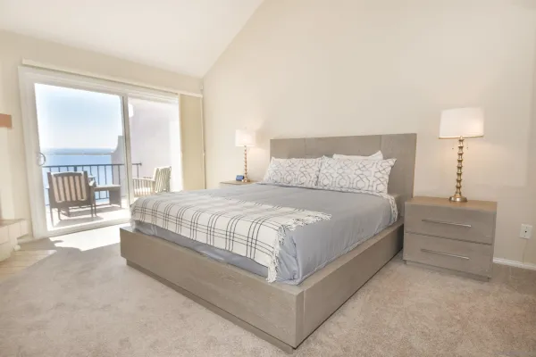 a large bed sitting in a bedroom next to a window