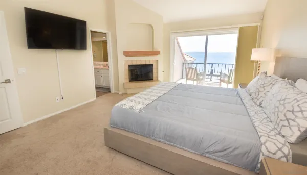 a spacious bedroom with a bed and a flat screen tv