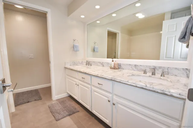 a bathroom with a granite countertop sink mirror and double