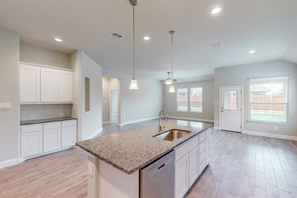 3017 Hampton Path Argyle, TX 76226 - Photo 8 of 37 a kitchen with granite countertop a sink a stove and a refrigerator