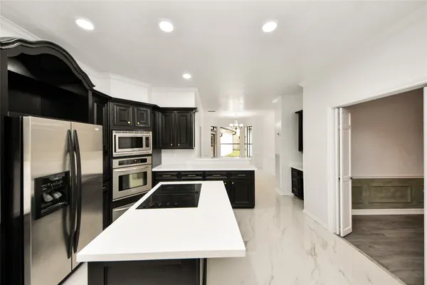 a kitchen with stainless steel appliances a refrigerator and a stove top oven