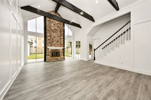 a view of an entryway with wooden floor fireplace and windows