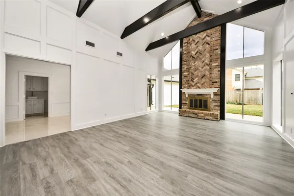 a view of empty room with wooden floor and fireplace