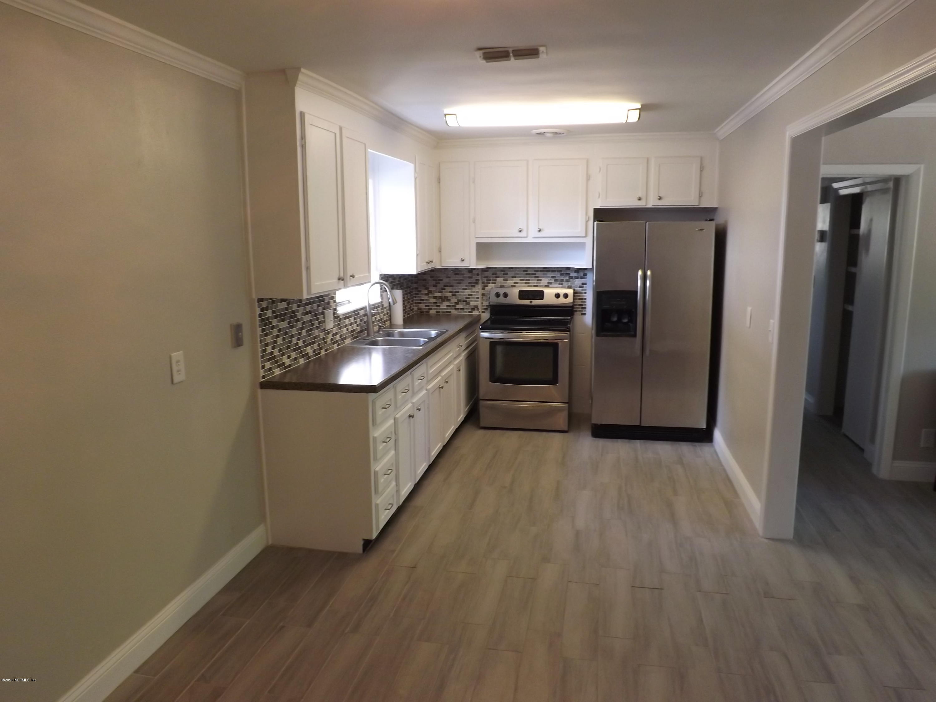 3565 Rogero Road Jacksonville, FL 32277 - Photo 11 of 74 a kitchen with granite countertop a refrigerator and a sink