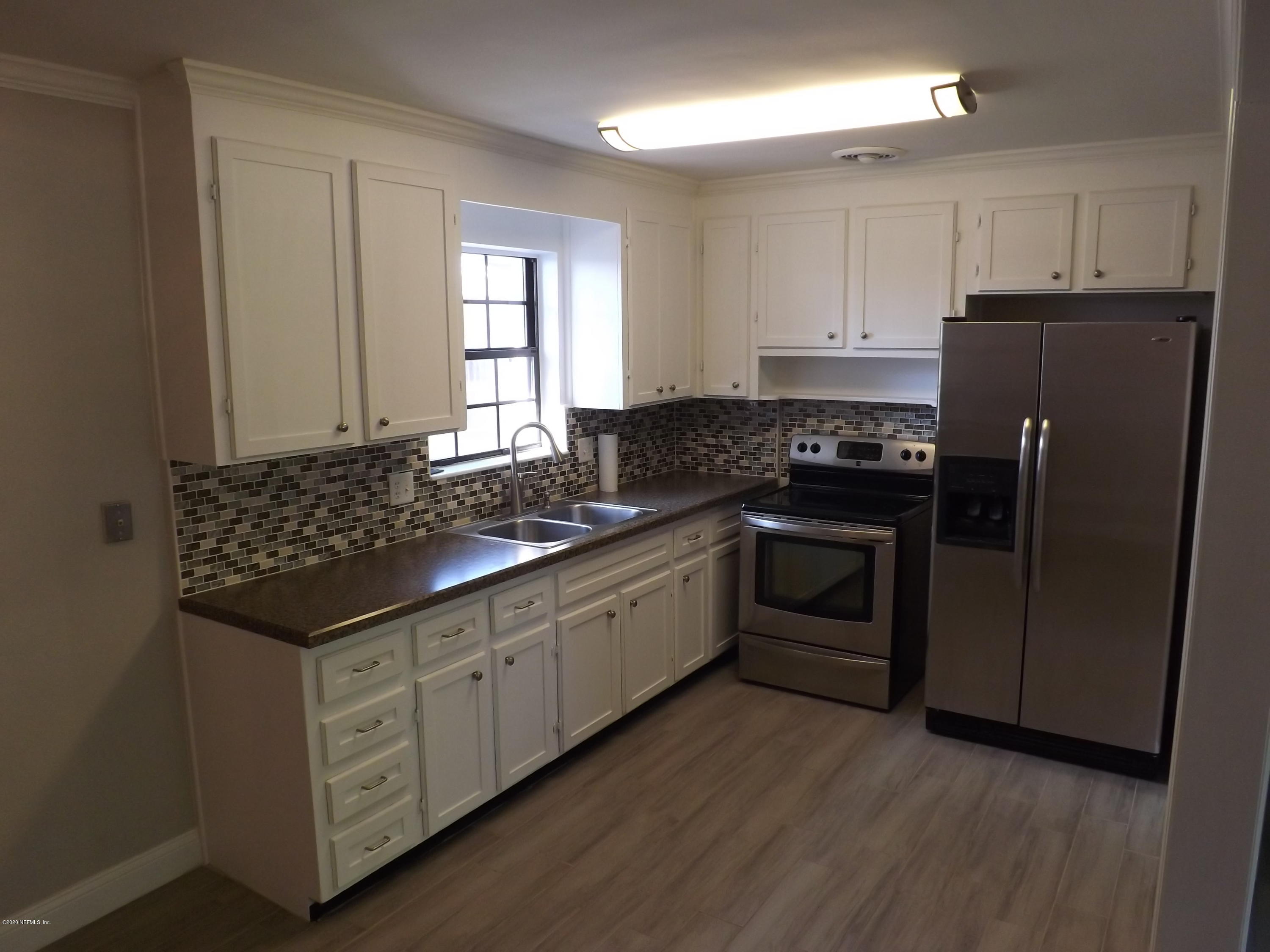 3565 Rogero Road Jacksonville, FL 32277 - Photo 12 of 74 a kitchen with granite countertop white cabinets and stainless steel appliances