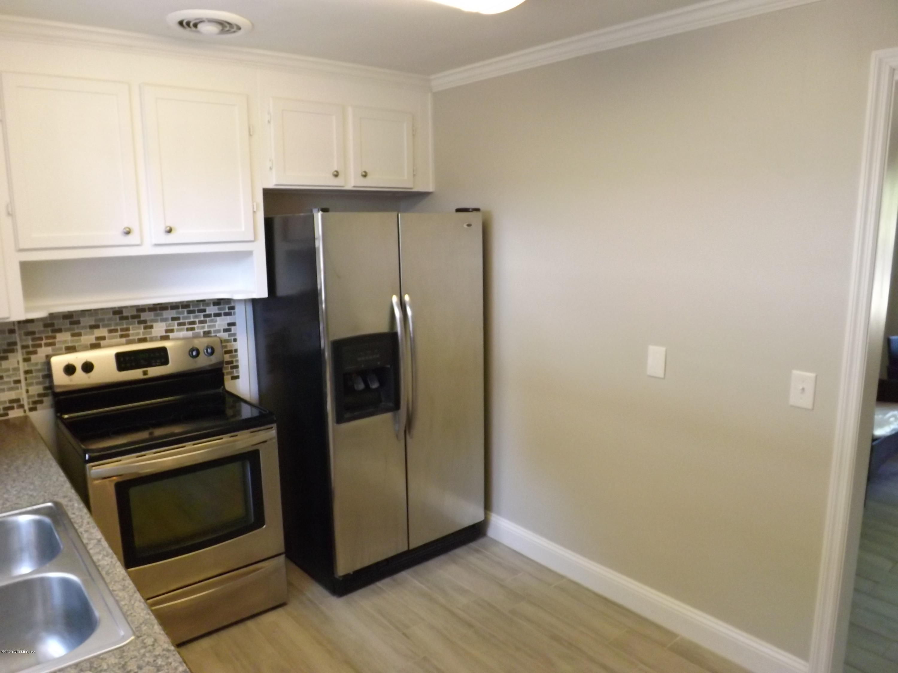 3565 Rogero Road Jacksonville, FL 32277 - Photo 13 of 74 a kitchen with a refrigerator stove and cabinets