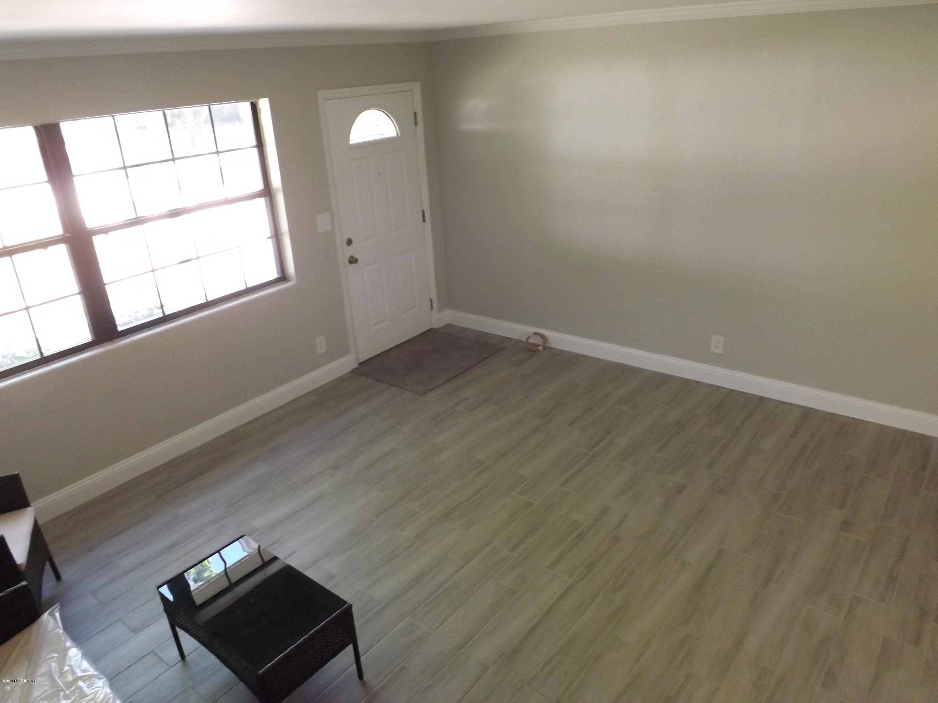 3565 Rogero Road Jacksonville, FL 32277 - Photo 18 of 74 an empty room with wooden floor and windows