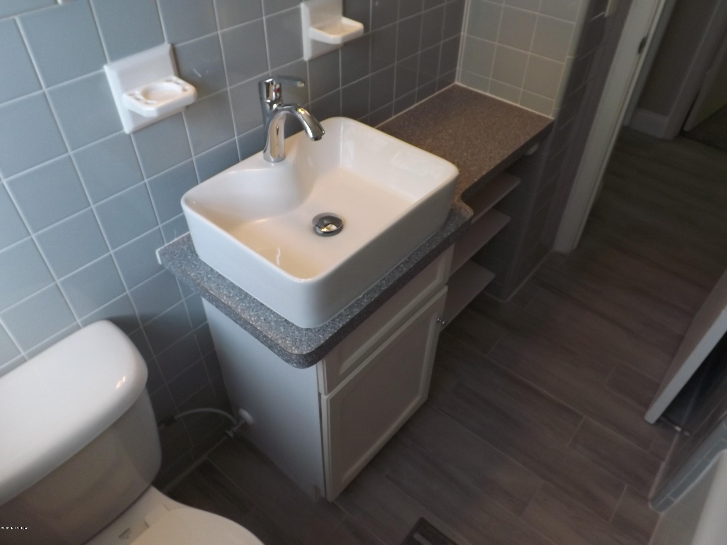 3565 Rogero Road Jacksonville, FL 32277 - Photo 25 of 74 a bathroom with a sink toilet and a mirror