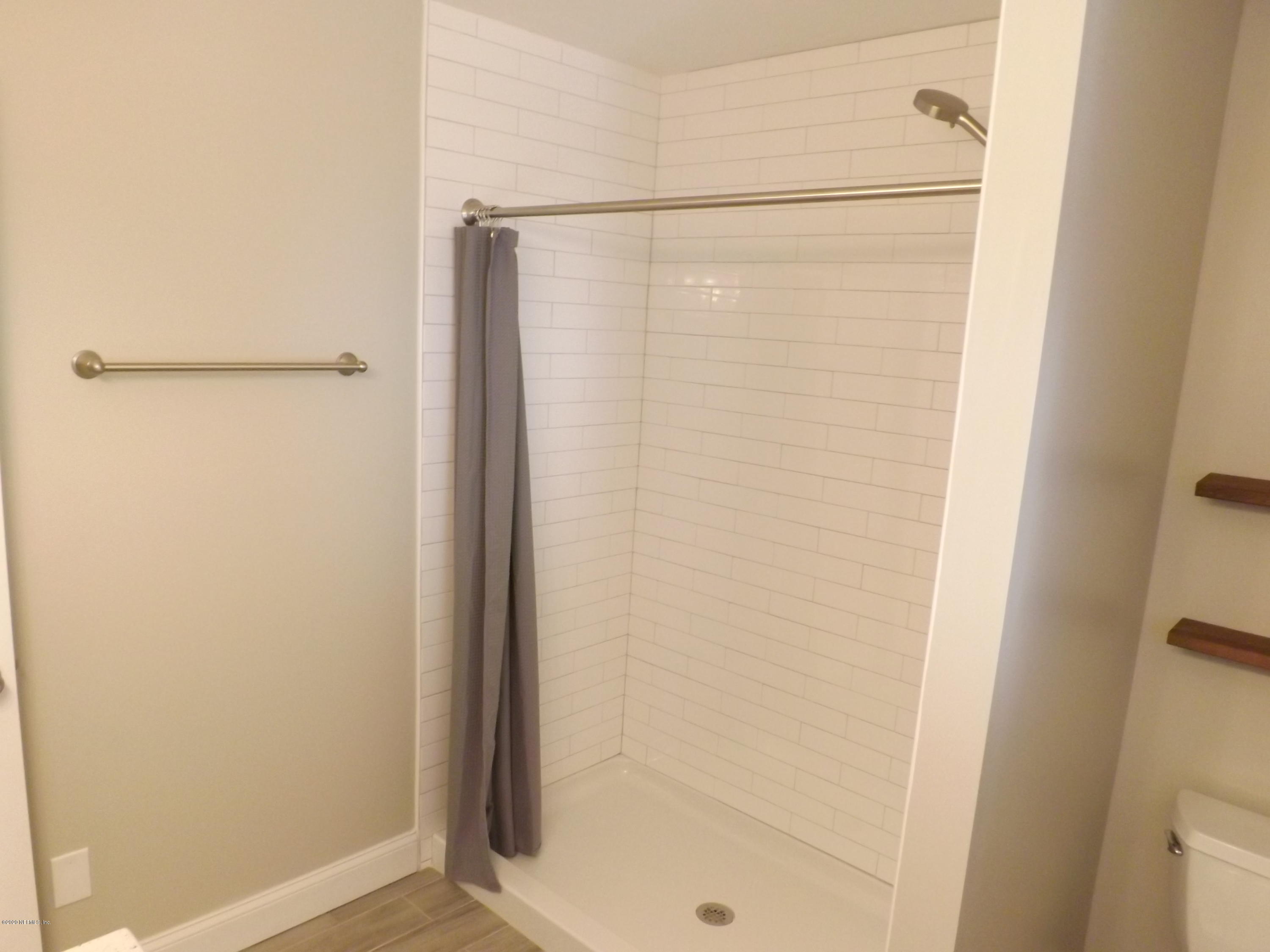 3565 Rogero Road Jacksonville, FL 32277 - Photo 6 of 74 a bathroom with a glass shower door