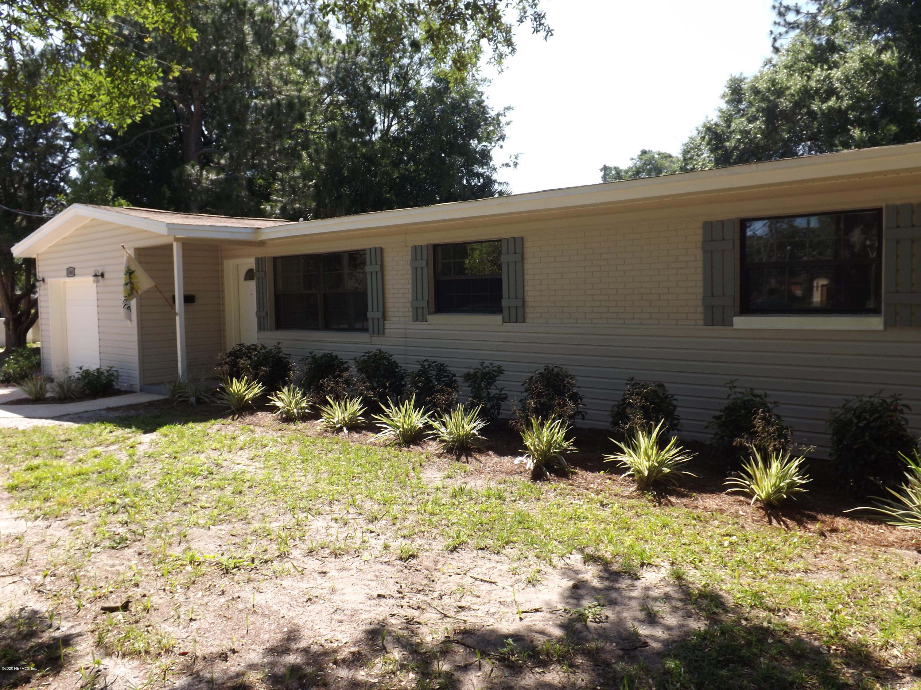 3565 Rogero Road Jacksonville, FL 32277 - Photo 67 of 74 a backyard of a house with potted plants and large tree