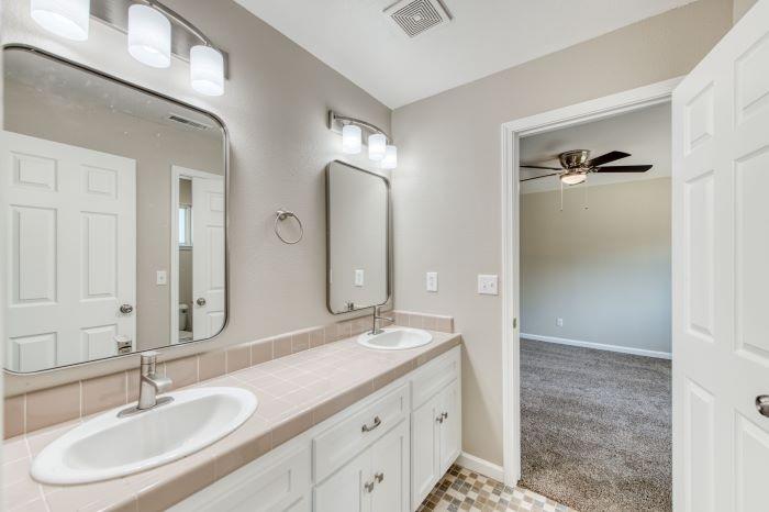 6153 Big Oak Road Sanger, CA 93657 - Photo 15 of 23 a bathroom with a double vanity sink and a mirror