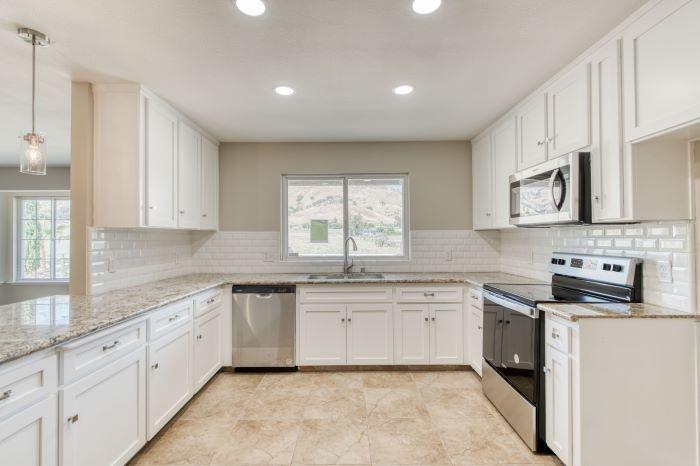 6153 Big Oak Road Sanger, CA 93657 - Photo 9 of 23 a kitchen with stainless steel appliances granite countertop white cabinets sink and window