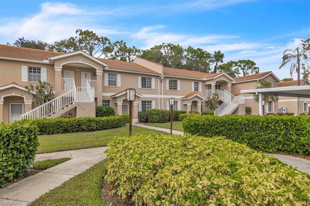 8075 Tiger Cove, Unit 1706 Naples, FL 34113 - Photo 48 of 50 Mediterranean / spanish-style house featuring stairs, a tile roof, stucco siding, and a front lawn