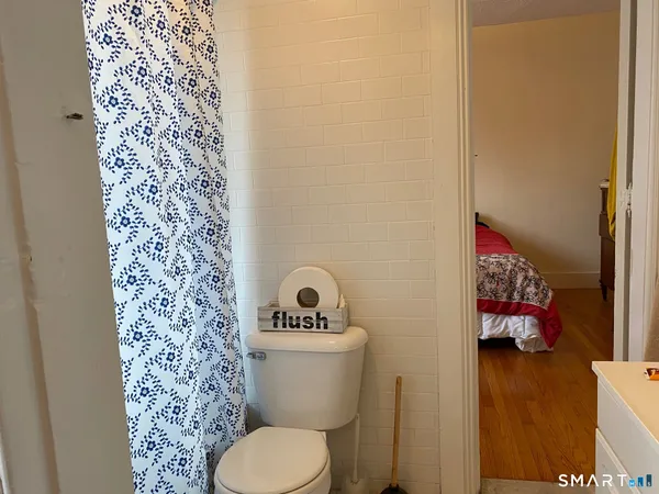 a bedroom with a bed and a flat tv screen on a dresser