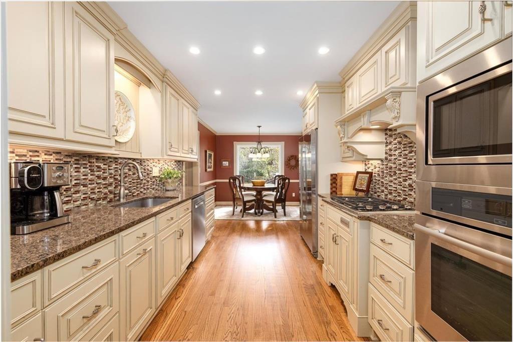 4890 Forestglade Court Smoke Rise, GA 30087 - Photo 21 of 50 a kitchen with stainless steel appliances kitchen island granite countertop a stove and a sink