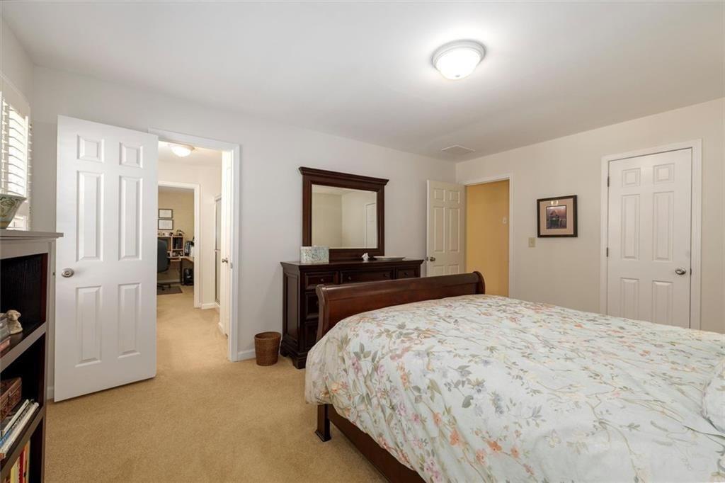 4890 Forestglade Court Smoke Rise, GA 30087 - Photo 32 of 50 a bedroom with a bed and a large mirror