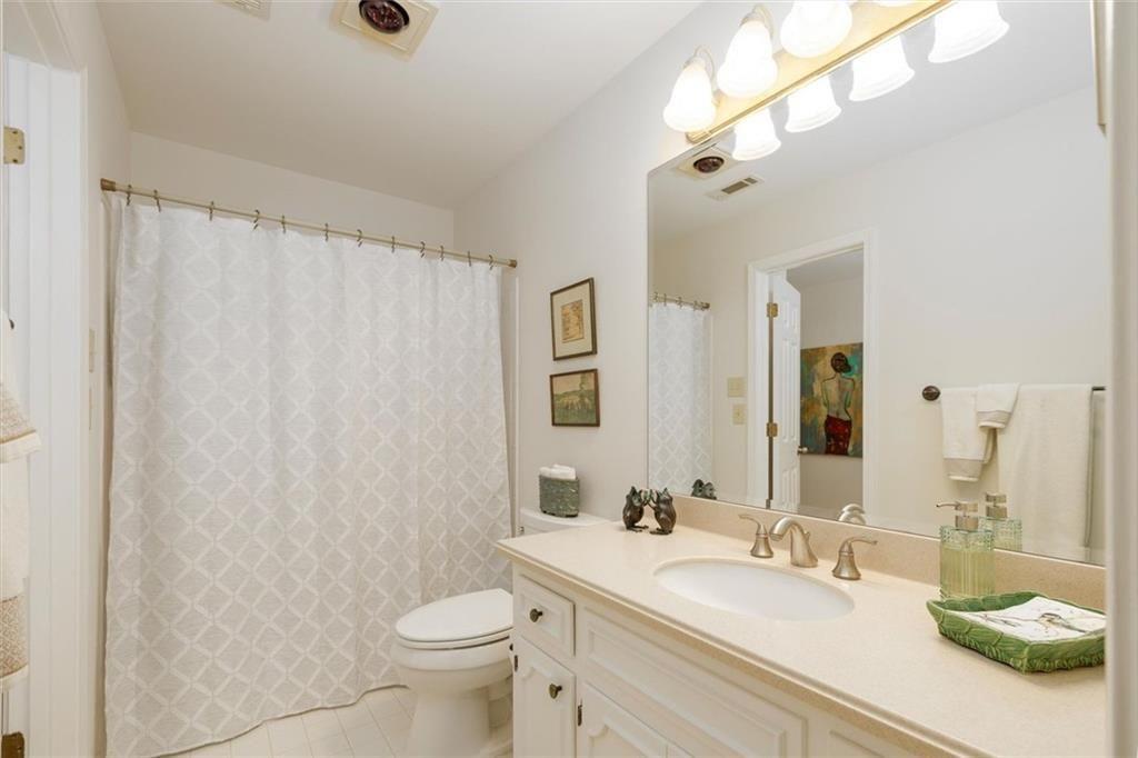 4890 Forestglade Court Smoke Rise, GA 30087 - Photo 40 of 50 a bathroom with a sink a toilet and a mirror