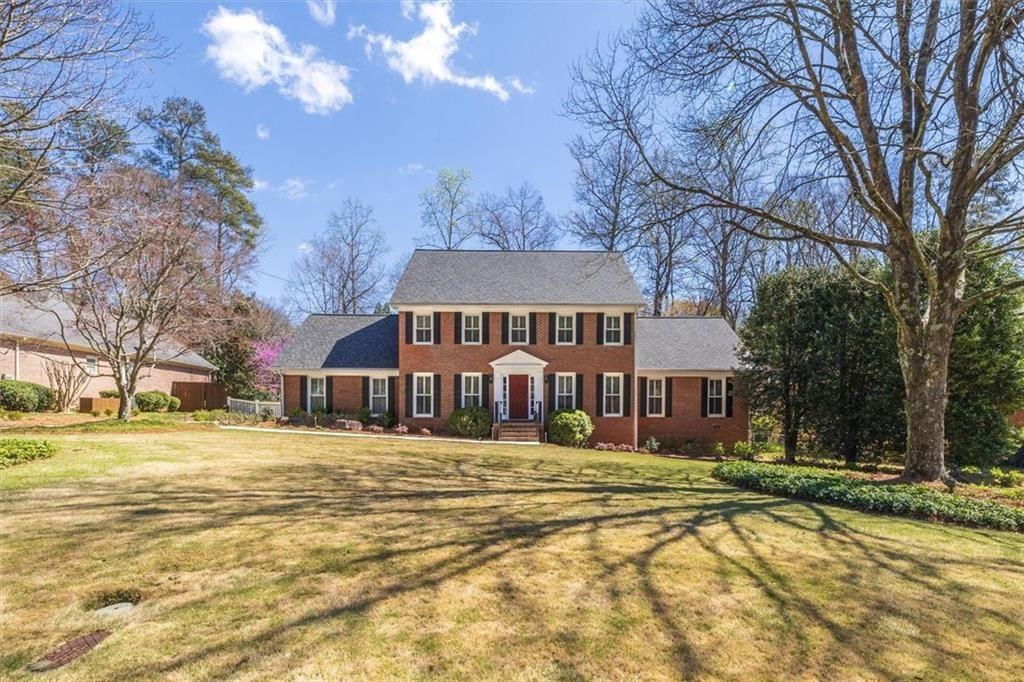 4890 Forestglade Court Smoke Rise, GA 30087 - Photo 6 of 50 a view of a white house with a yard and a large tree