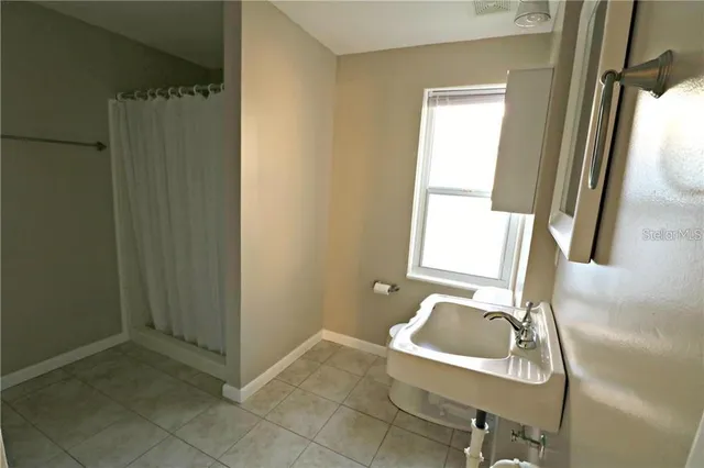 a bathroom with a window sink and mirror