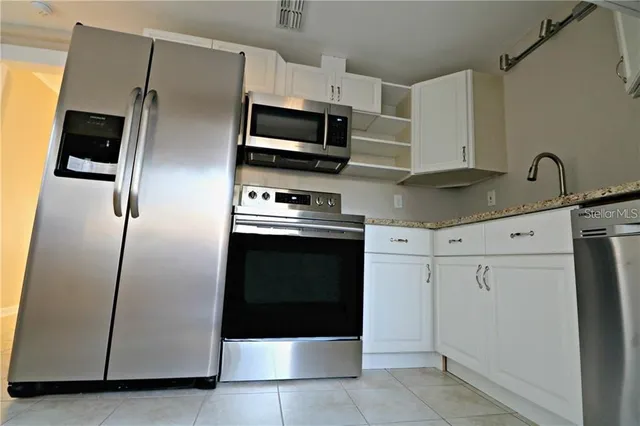 a kitchen with cabinets and steel stainless steel appliances