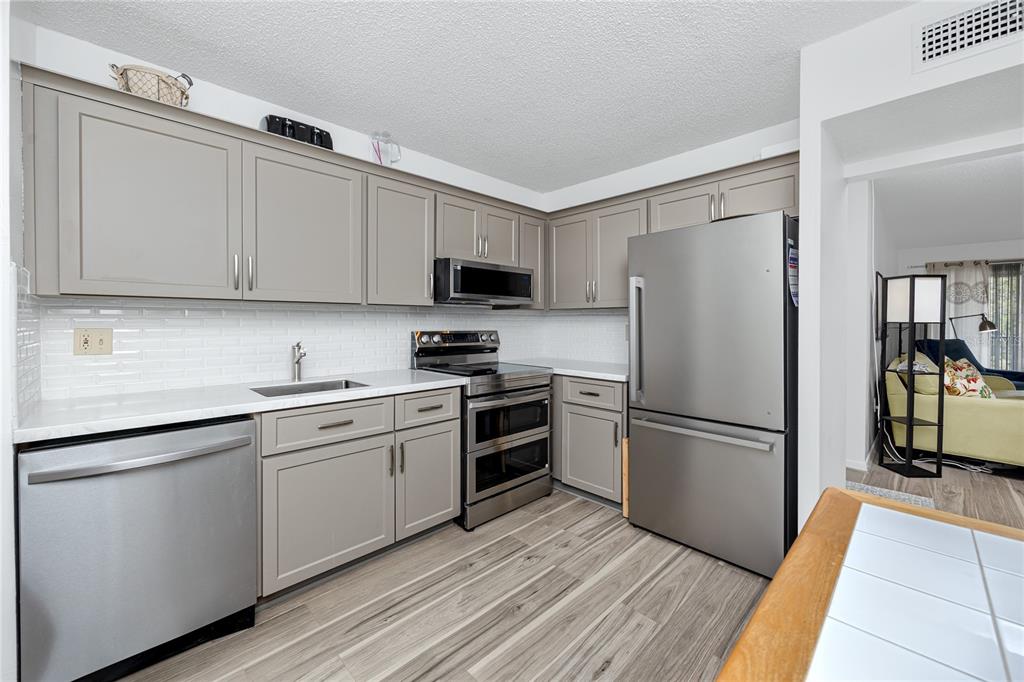 2207 Belleair Road, Unit B30 Clearwater, FL 33764 - Photo 7 of 39 a kitchen with cabinets stainless steel appliances and a window