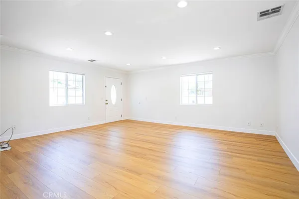 an empty room with wooden floor and window