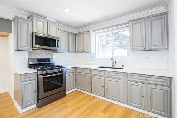a kitchen with cabinets stainless steel appliances and a window