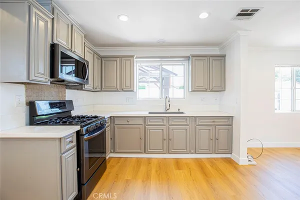 a kitchen with stainless steel appliances granite countertop a sink stove and microwave