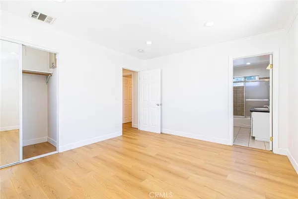 a view of an empty room with wooden floor