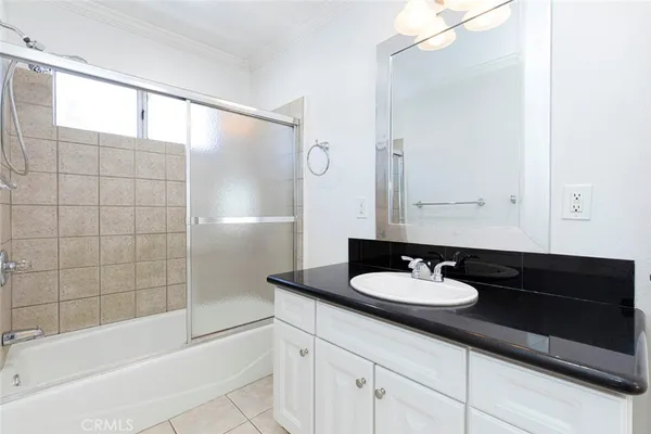 a bathroom with a granite countertop sink a mirror and a bathtub