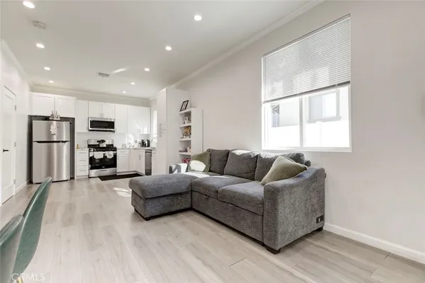 a living room with furniture and a open kitchen view