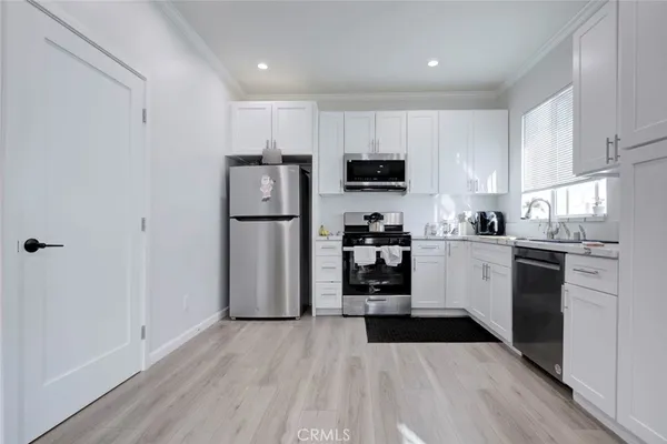 a kitchen with stainless steel appliances a refrigerator sink and microwave