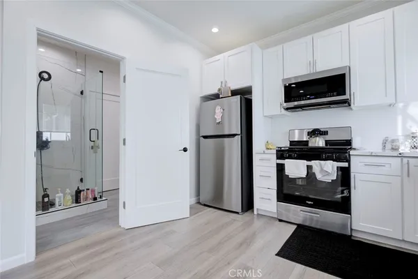 a kitchen with a refrigerator and a stove top oven