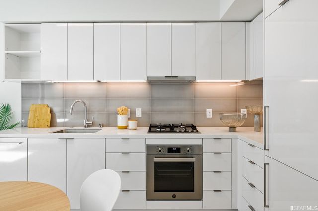 a kitchen with a sink a stove and cabinets