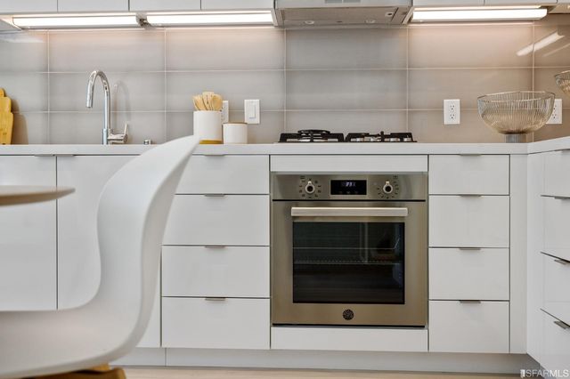 a close view of a stove top oven and an empty room