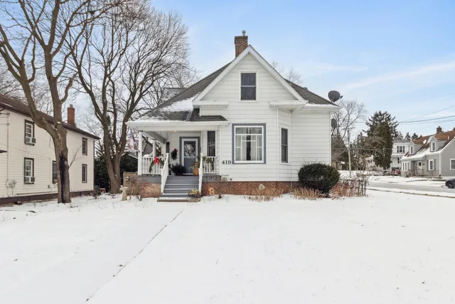 a view of a house with a yard covered in snow