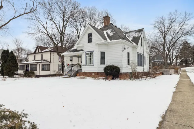 a view of a white house with a yard covered in snow