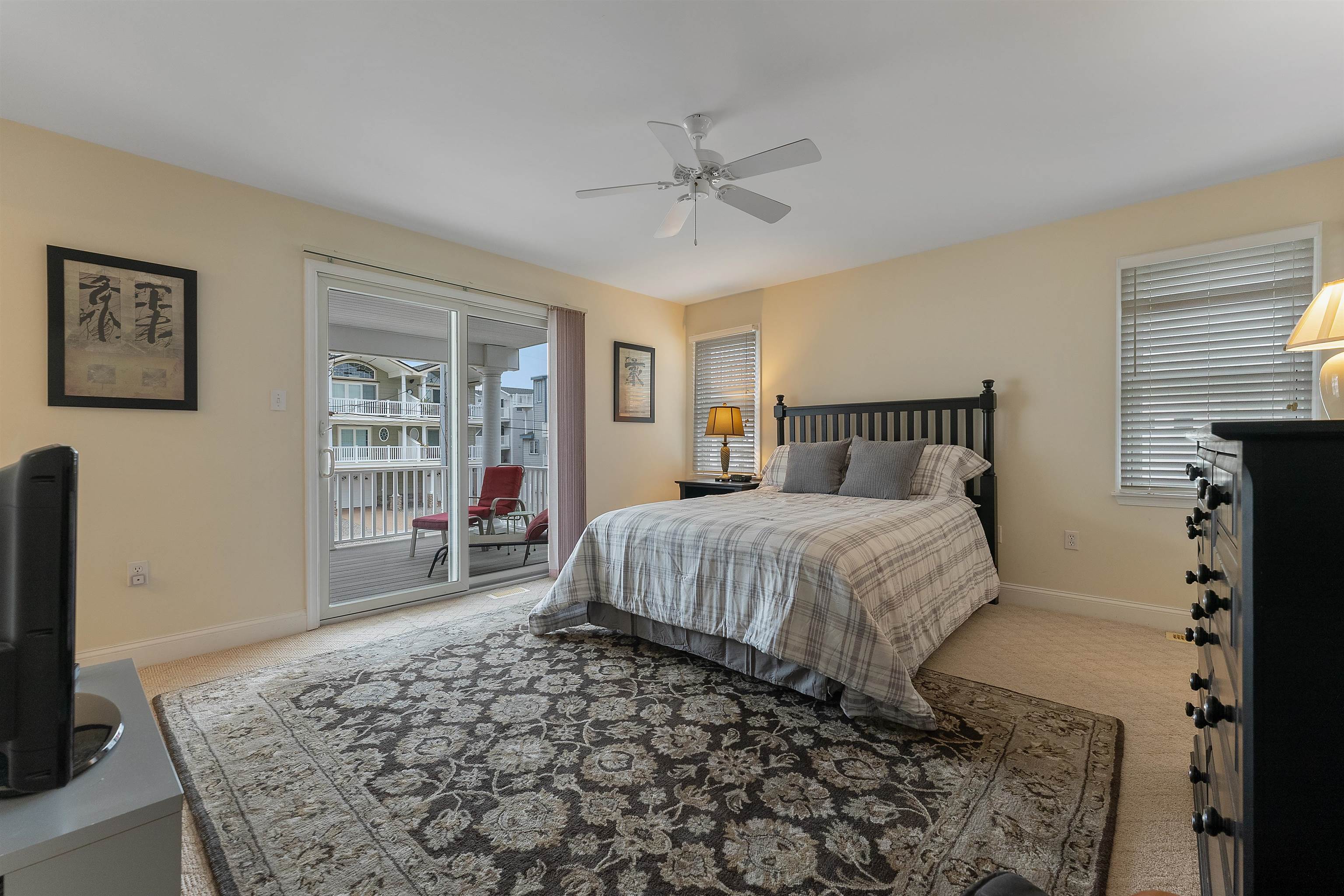 33 74th Street, Unit WEST Sea Isle City, NJ 08243 - Photo 27 of 48 a bedroom with a large bed and a flat tv screen