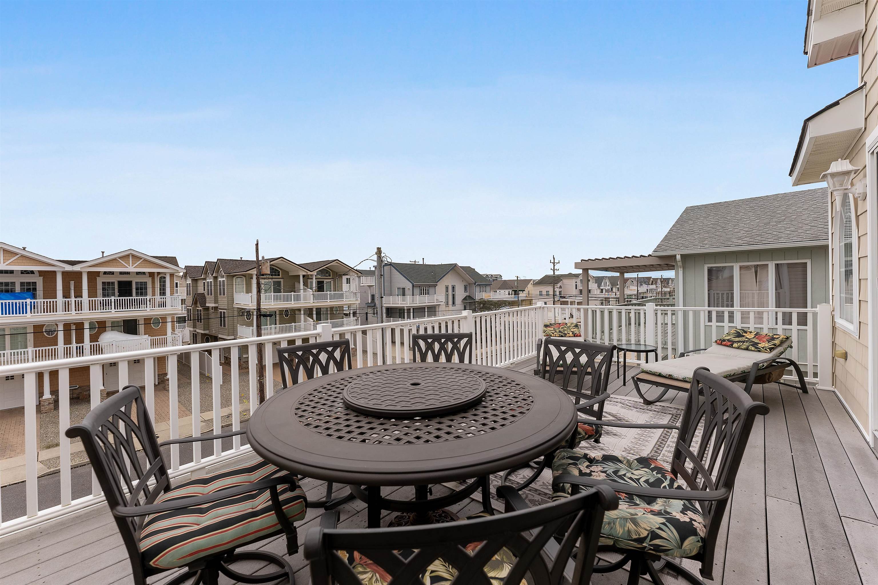 33 74th Street, Unit WEST Sea Isle City, NJ 08243 - Photo 7 of 48 a view of a chairs and table on the terrace