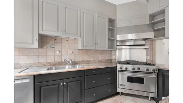 a kitchen with stainless steel appliances granite countertop a refrigerator a stove and a wooden floors