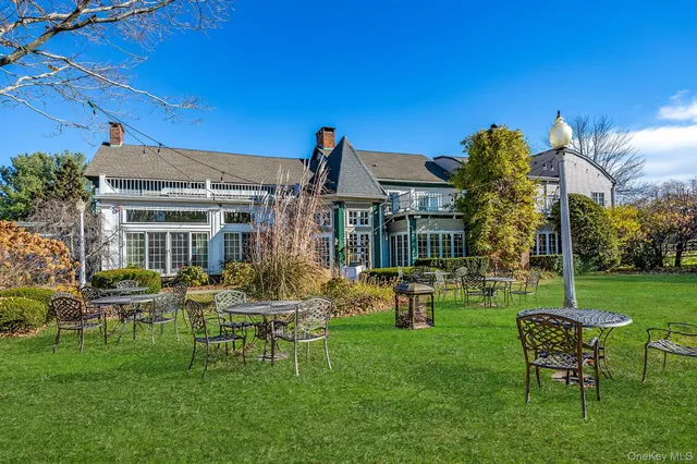 a view of a house with a backyard and chairs
