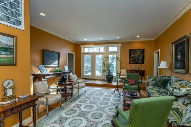 a living room with furniture a flat screen tv and a floor to ceiling window