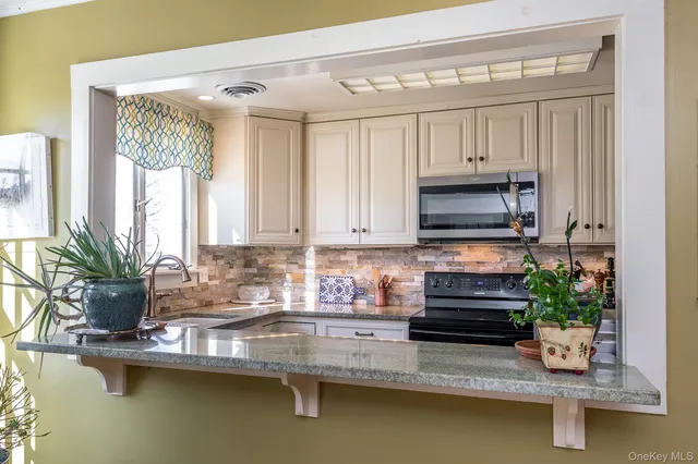 a kitchen with a large window appliances and cabinets