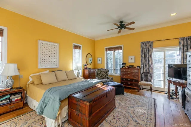 a bedroom with a bed a couch and a flat tv screen on dresser