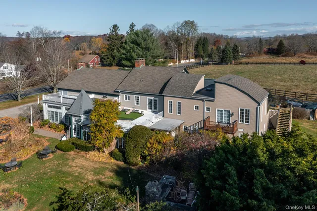 an aerial view of a house with a yard and a large tree