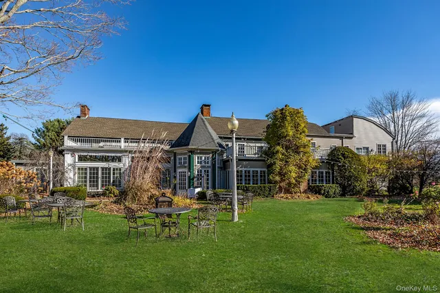 a view of a house with a big yard potted plants and large tree
