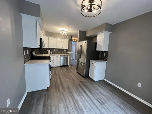 a kitchen with a refrigerator cabinets and wooden floor